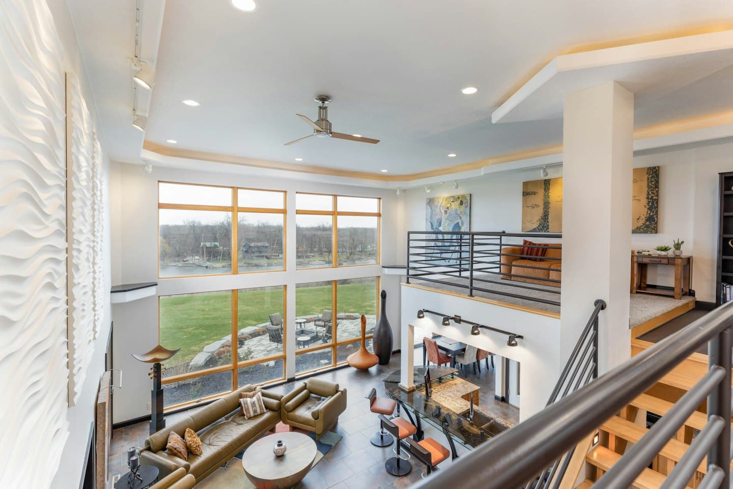 Modern open plan living room overlooking a green lawn.