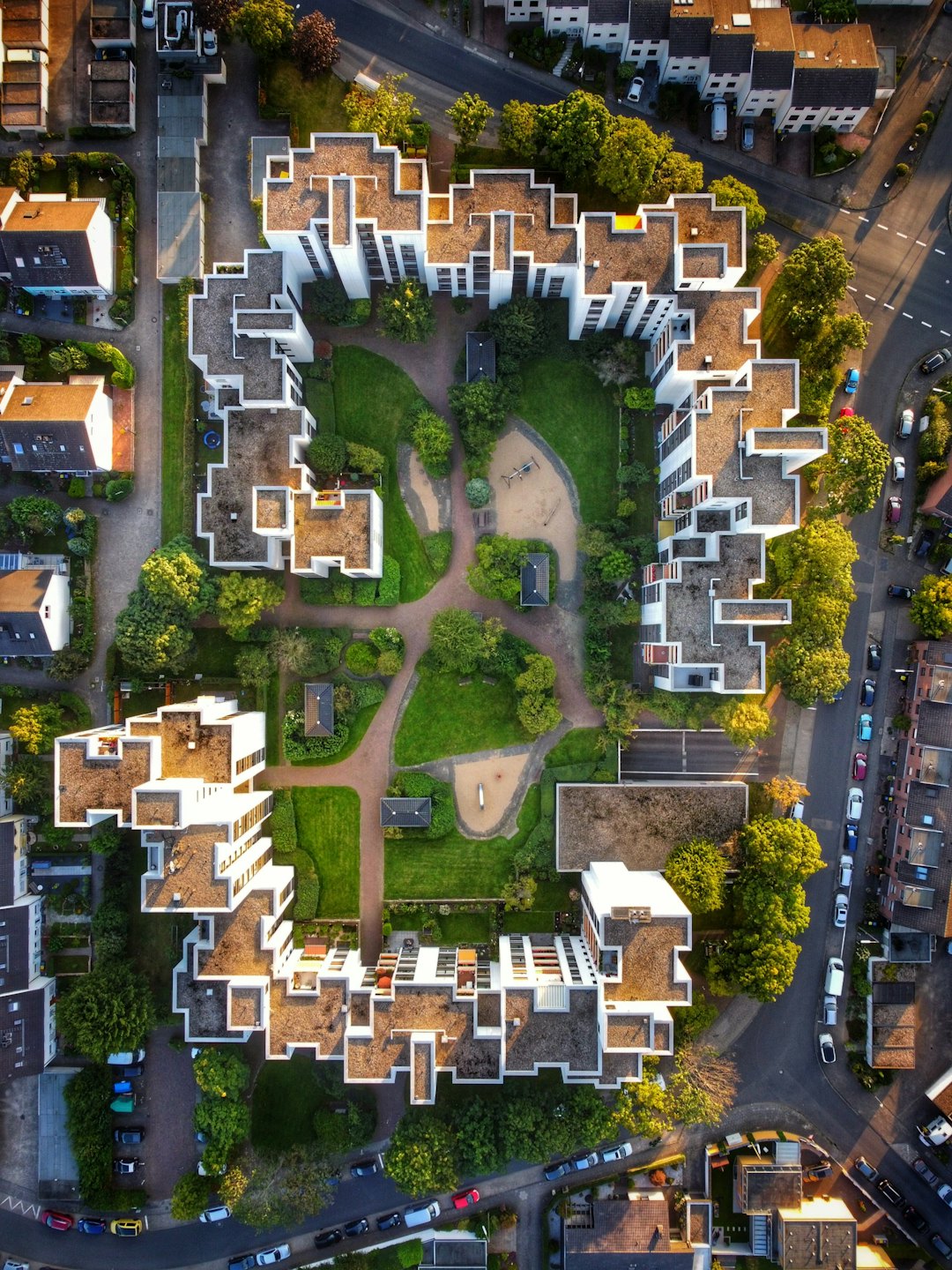 Modern residential complex with a central green courtyard and pathways.